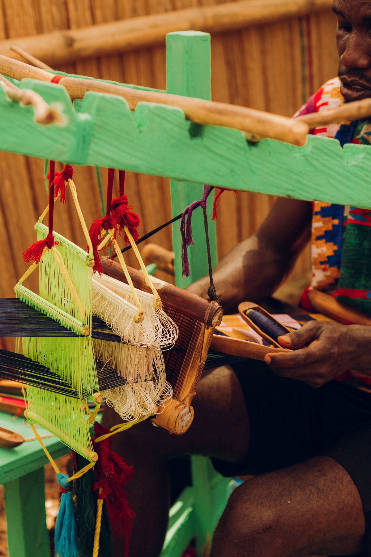A craftsman weaving kente cloth on a traditional loom in Accra, Ghana
